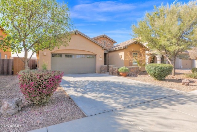 single story home with a garage, concrete driveway, a tile roof, fence, and stucco siding