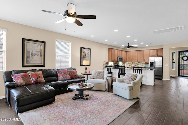 living area featuring dark wood-type flooring, recessed lighting, visible vents, and a healthy amount of sunlight