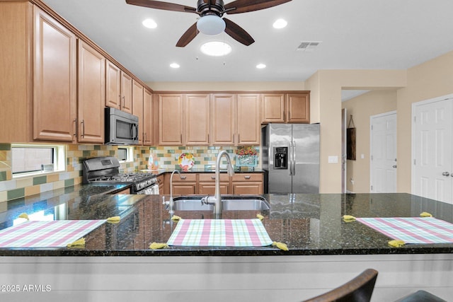 kitchen with stainless steel appliances, visible vents, a sink, and decorative backsplash