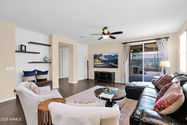 living area featuring dark wood-style floors, a ceiling fan, visible vents, and baseboards