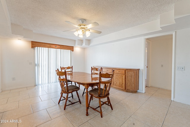 tiled dining room with ceiling fan and a textured ceiling