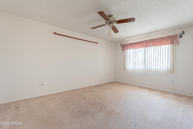 carpeted spare room featuring ceiling fan and a textured ceiling