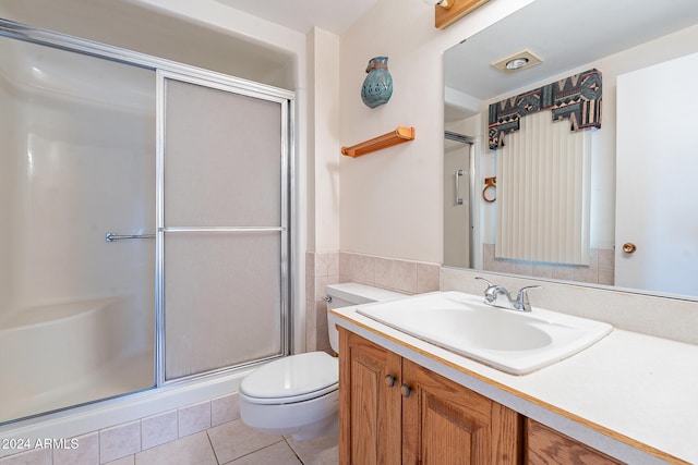 bathroom with vanity, tile patterned flooring, toilet, and an enclosed shower