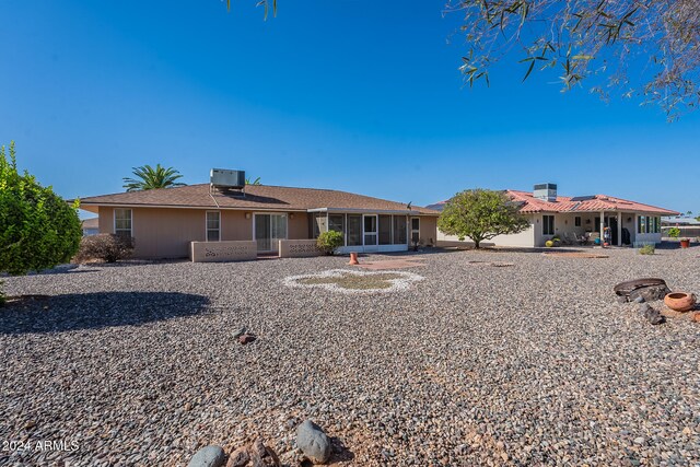 back of property with a sunroom, a patio area, and cooling unit