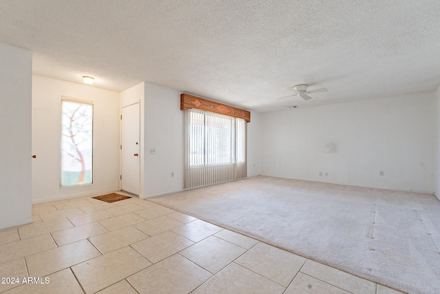 entryway featuring ceiling fan, a textured ceiling, and light colored carpet