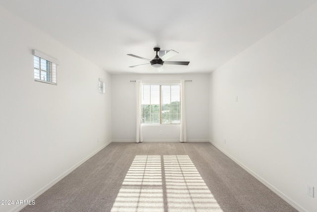 spare room featuring light carpet and ceiling fan