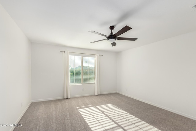 carpeted spare room with ceiling fan