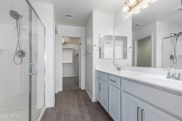 bathroom featuring a shower with door, vanity, and hardwood / wood-style flooring