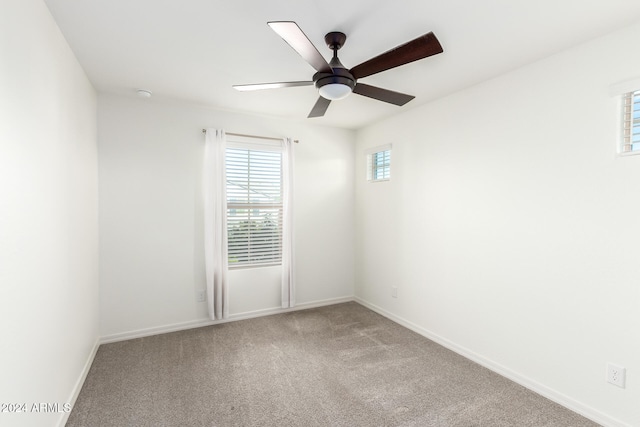 carpeted spare room featuring ceiling fan