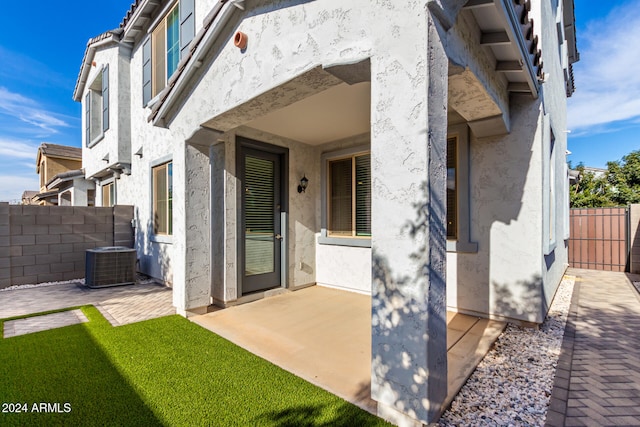 property entrance with central air condition unit and a patio area