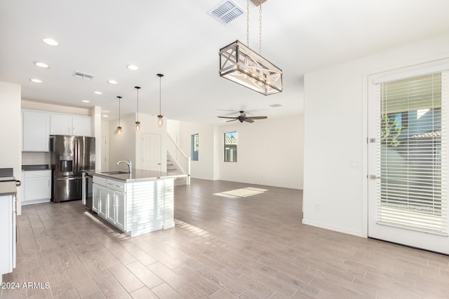 kitchen featuring a center island with sink, appliances with stainless steel finishes, light hardwood / wood-style flooring, and plenty of natural light