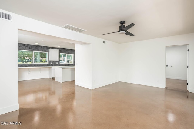 empty room with concrete floors and ceiling fan