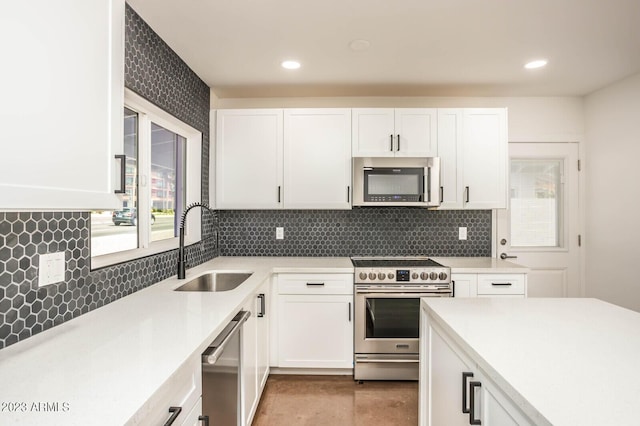 kitchen featuring white cabinetry, sink, tasteful backsplash, and stainless steel appliances