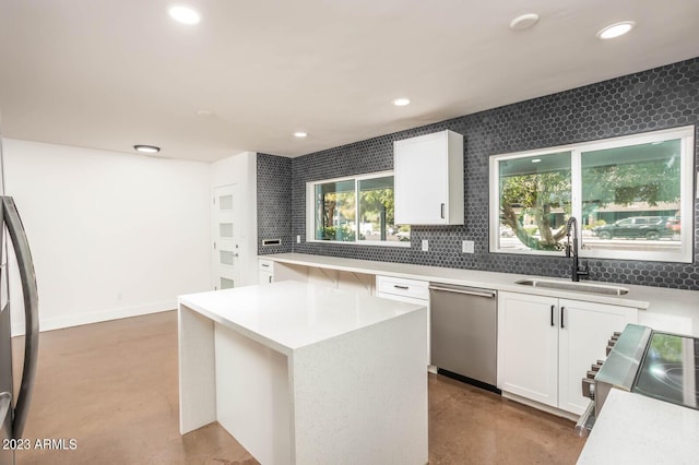 kitchen with sink, concrete flooring, stainless steel appliances, a center island, and white cabinets