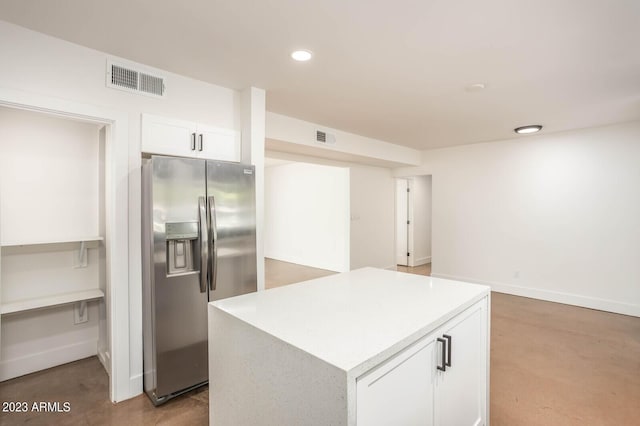 kitchen with white cabinetry, a kitchen island, and stainless steel refrigerator with ice dispenser