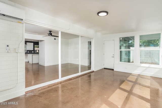 unfurnished room with concrete floors, an AC wall unit, and ceiling fan