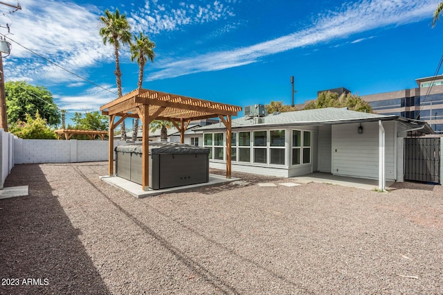 exterior space featuring a hot tub, a pergola, and a patio area