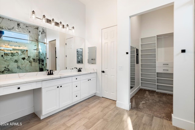 bathroom featuring hardwood / wood-style floors, vanity, and a shower with shower door