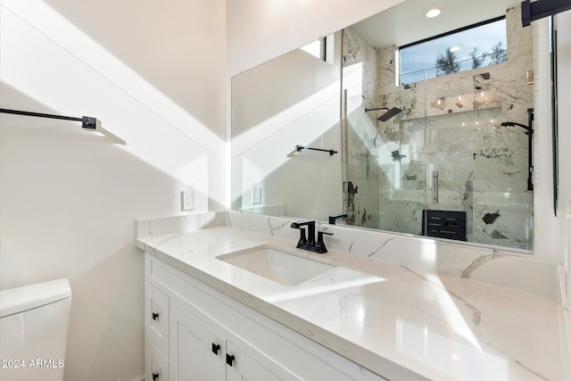 bathroom with an enclosed shower, vanity, and toilet