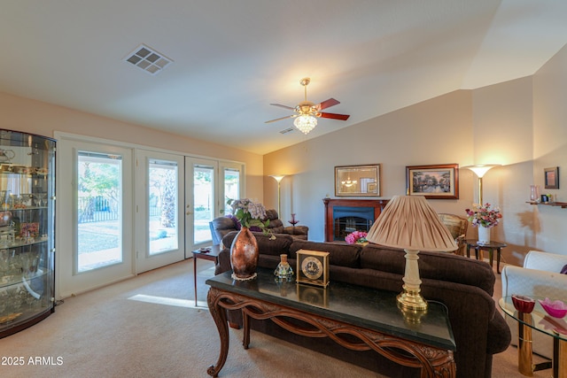 carpeted living room with ceiling fan and lofted ceiling