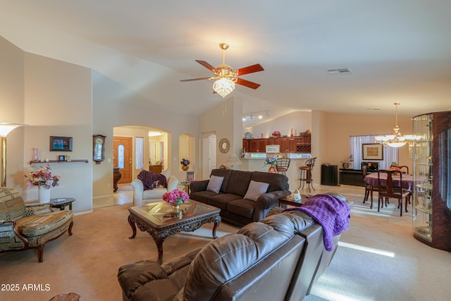 living room featuring light colored carpet, lofted ceiling, and ceiling fan with notable chandelier