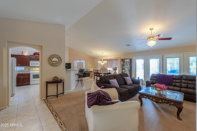 living room featuring light tile patterned flooring, lofted ceiling, and ceiling fan with notable chandelier