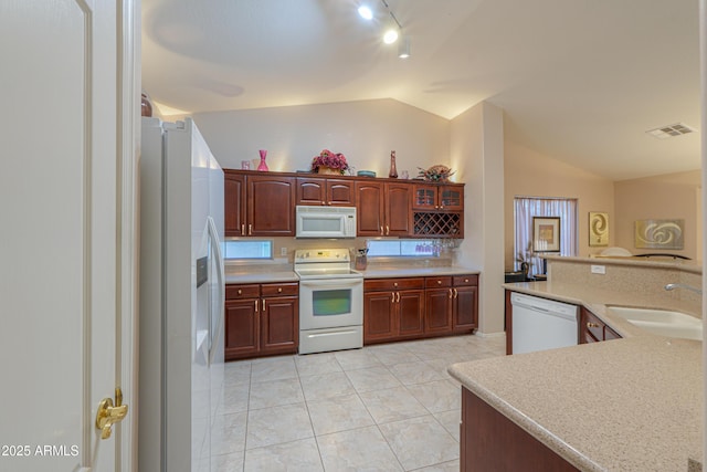 kitchen featuring vaulted ceiling, sink, light tile patterned floors, kitchen peninsula, and white appliances