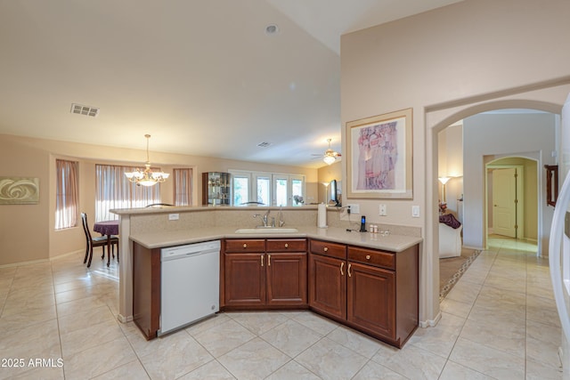 kitchen with pendant lighting, sink, light tile patterned floors, dishwasher, and vaulted ceiling