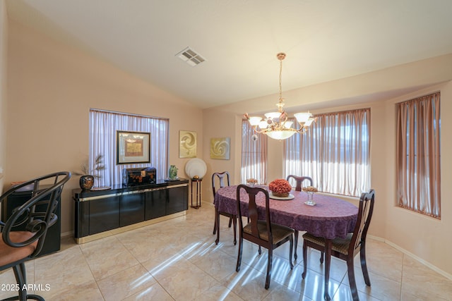 dining room with vaulted ceiling and an inviting chandelier