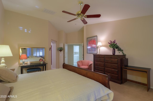 bedroom featuring light carpet, ensuite bath, vaulted ceiling, and ceiling fan