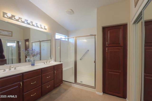 bathroom featuring vanity, a shower with door, and vaulted ceiling