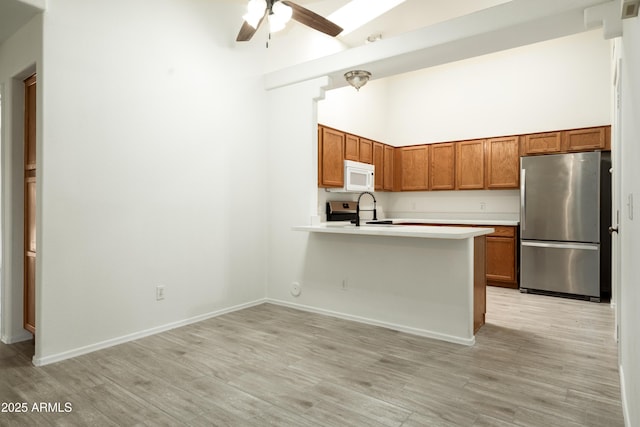 64 N 63rd St N Unit 33, Mesa, AZ 85205 - kitchen featuring appliances with stainless steel finishes, high vaulted ceiling, light countertops, brown cabinets, and ceiling fan