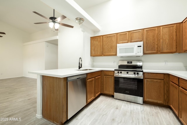 64 N 63rd St N Unit 33, Mesa, AZ 85205 - kitchen with appliances with stainless steel finishes, ceiling fan, light wood-style flooring, brown cabinetry, and lofted ceiling