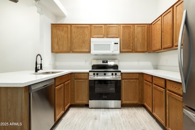64 N 63rd St N Unit 33, Mesa, AZ 85205 - kitchen with appliances with stainless steel finishes, brown cabinetry, a peninsula, light countertops, and light wood-type flooring