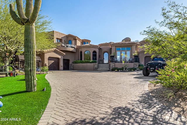 mediterranean / spanish-style home with a balcony and a front lawn