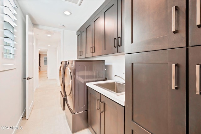 laundry room with cabinets, sink, and washing machine and dryer