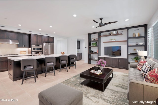 tiled living room with ceiling fan and sink