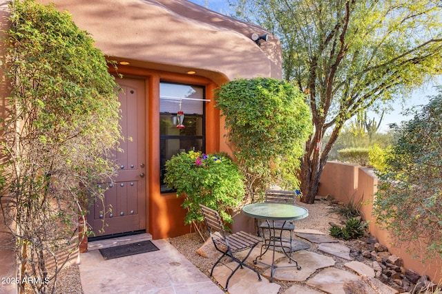 property entrance featuring fence and a patio