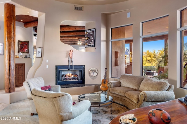 living room featuring a tile fireplace and visible vents