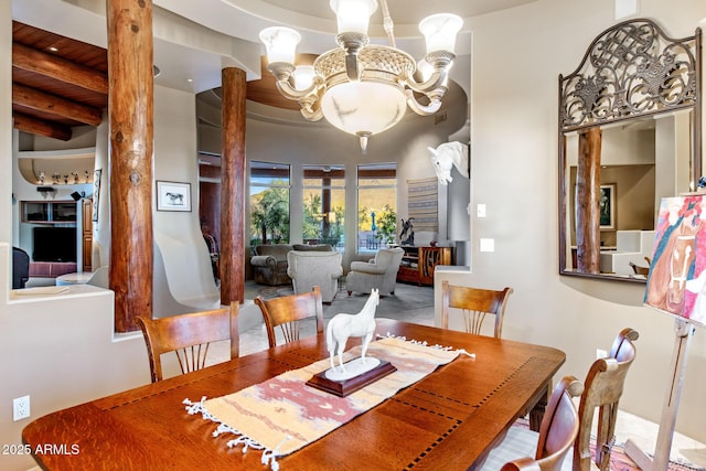 dining area featuring an inviting chandelier and decorative columns