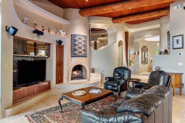 living room with wood ceiling, light tile patterned floors, a lit fireplace, and beam ceiling