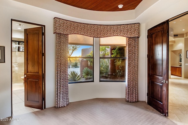 empty room with a tray ceiling and wooden ceiling