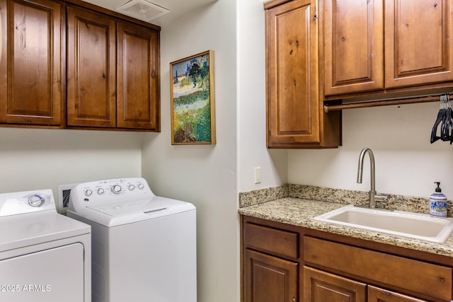 laundry area featuring visible vents, washer and clothes dryer, a sink, and cabinet space