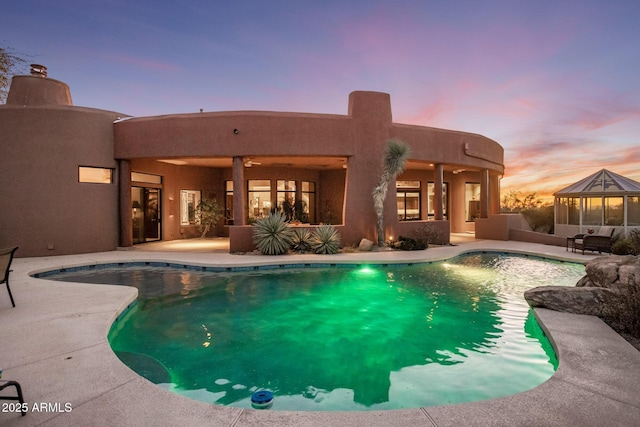 outdoor pool featuring a ceiling fan, a patio area, and a gazebo