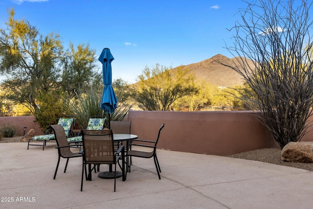 view of patio / terrace with fence, a mountain view, and outdoor dining area