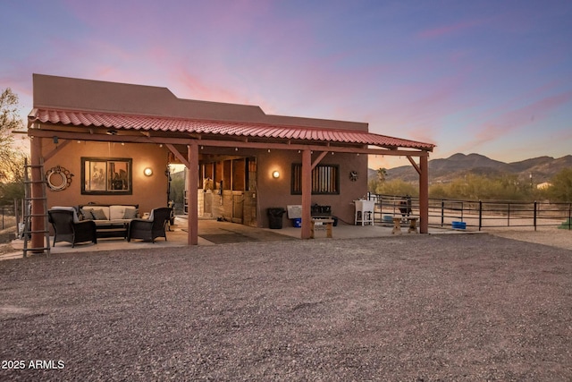 rear view of house featuring outdoor lounge area, a mountain view, a tiled roof, and stucco siding