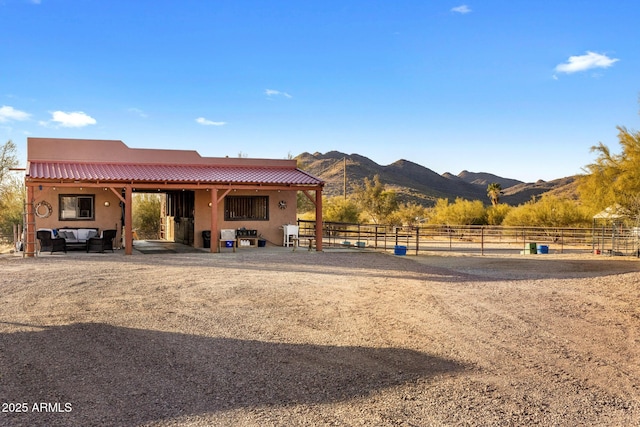 exterior space featuring a rural view, a mountain view, a tiled roof, and stucco siding