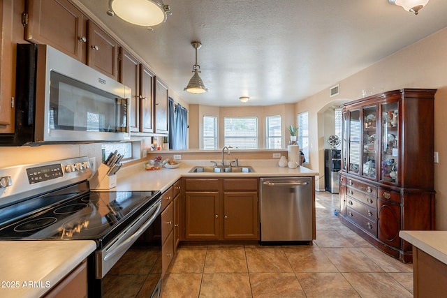 15211 N 89th Ave, Peoria, AZ 85381 - kitchen with appliances with stainless steel finishes, a sink, light countertops, a peninsula, and decorative light fixtures