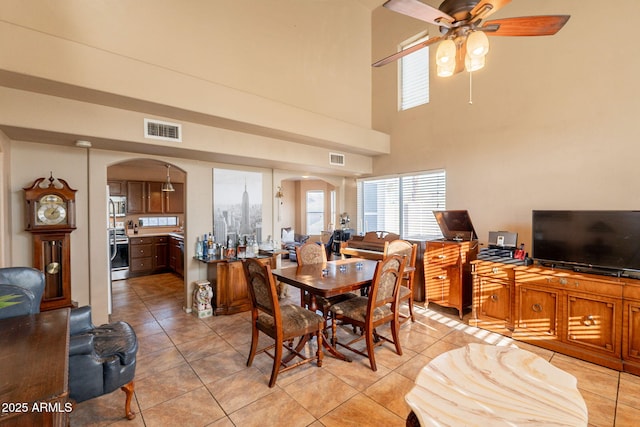 15211 N 89th Ave, Peoria, AZ 85381 - dining room with arched walkways, light tile patterned floors, a ceiling fan, and a towering ceiling