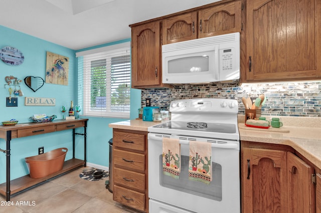 kitchen with decorative backsplash, white appliances, and light tile patterned floors